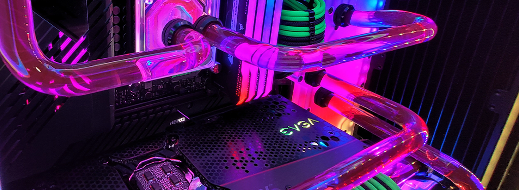 Close-up view of an illuminated computer interior showcasing a water cooling system with translucent tubes, surrounded by multi-colored LED lights. The components include an EVGA graphics card and a detailed motherboard.