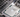 Applying thermal paste to a CPU on a motherboard, showing a close-up of a hand holding a syringe to spread the paste evenly for optimal heat transfer.