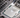 Applying thermal paste to a CPU on a motherboard, showing a close-up of a hand holding a syringe to spread the paste evenly for optimal heat transfer.