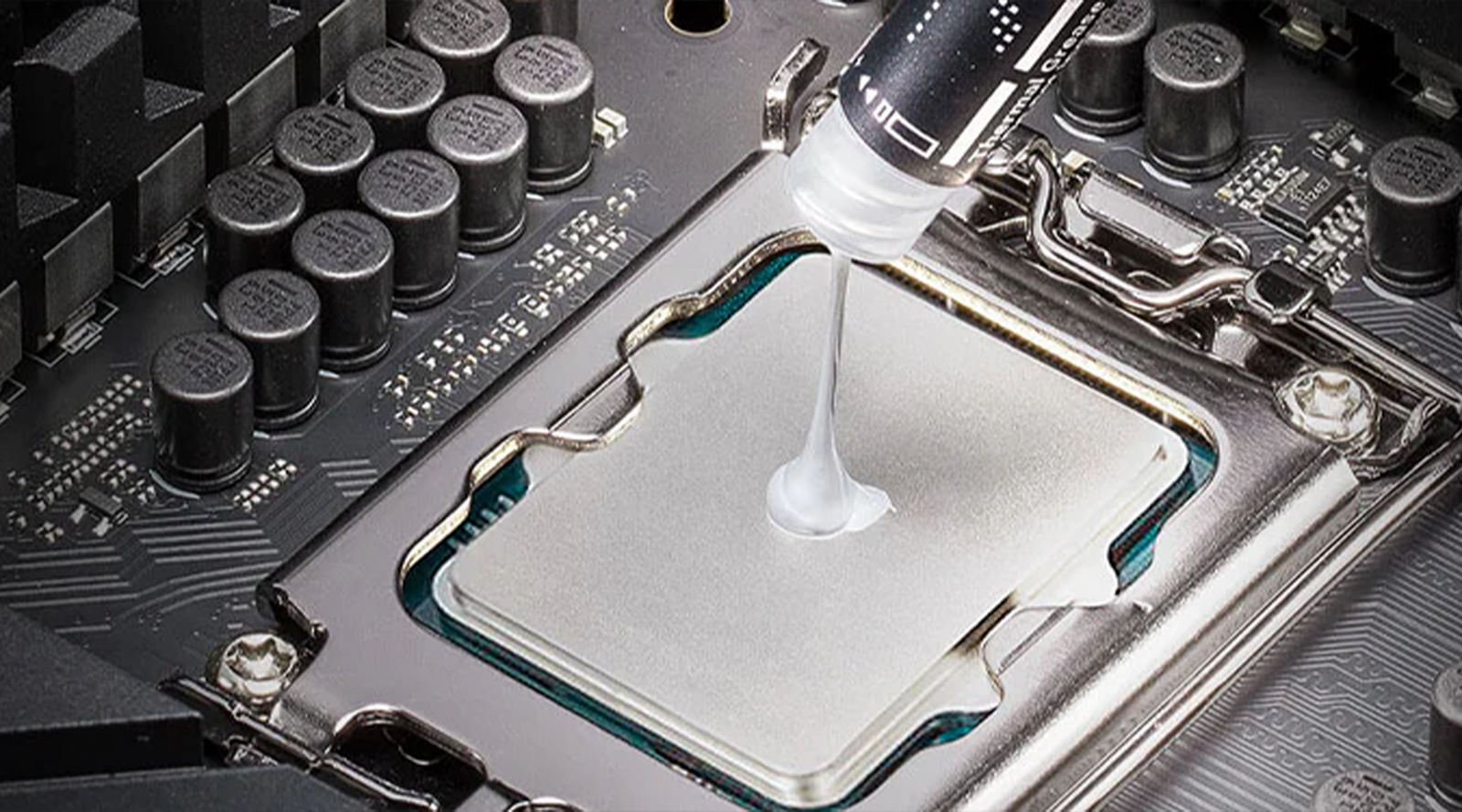 Applying thermal paste to a CPU on a motherboard, showing a close-up of a hand holding a syringe to spread the paste evenly for optimal heat transfer.